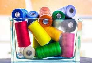 colorful threads in a glass container